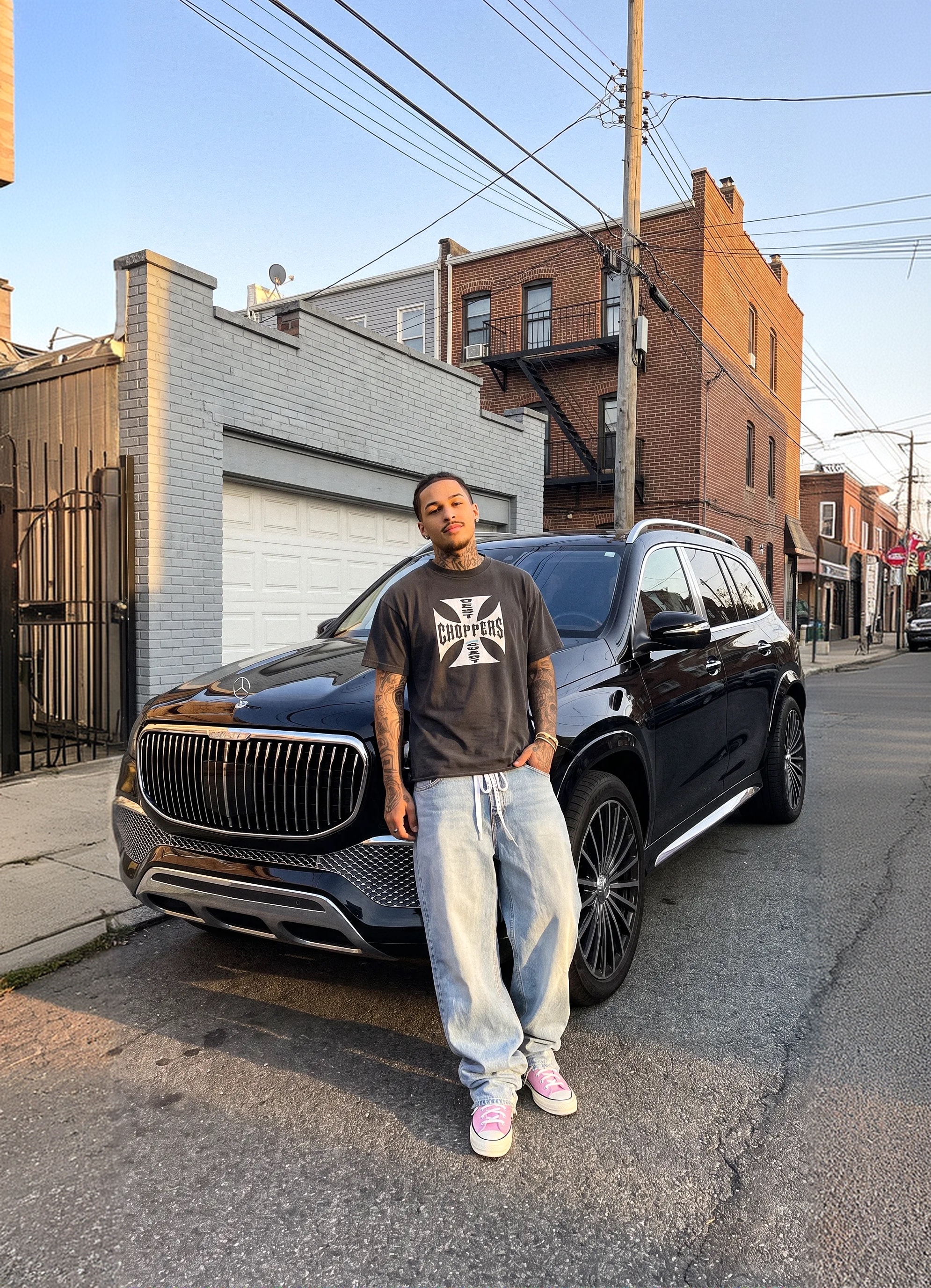 Model in a graphic tee next to a black SUV