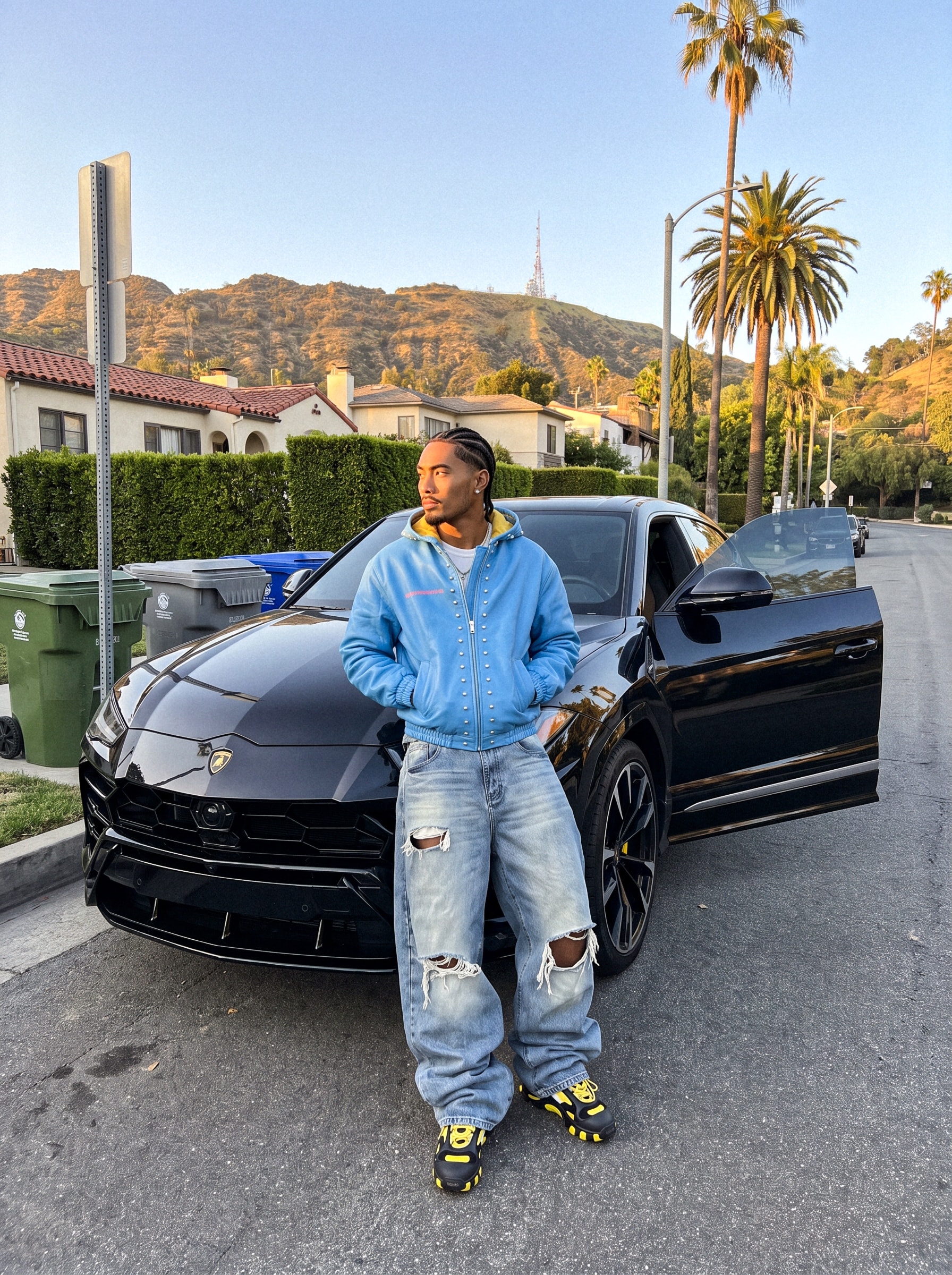 Autom: model in a blue hoodie leaning on a black SUV